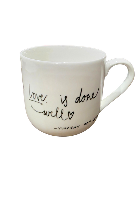 White mug with 'love is done well' text on a white background